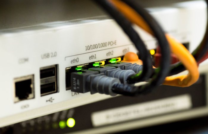 Detailed close-up of ethernet cables and network connections on a router, showcasing modern technology.