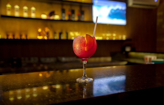 Chic cocktail glass on a polished bar counter in a warm-lit indoor setting.