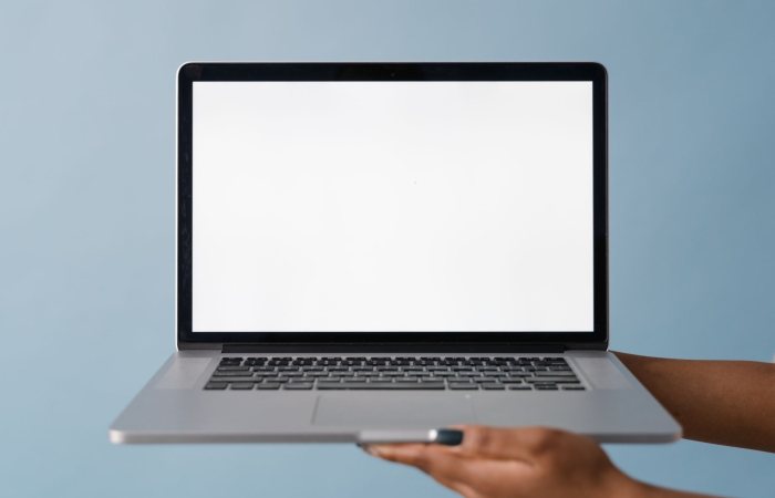 Close-up of a laptop held by a hand, perfect for tech product mockups with blue background.