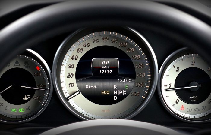 Close-up image of a car dashboard highlighting speedometer, odometer, and temperature gauge.