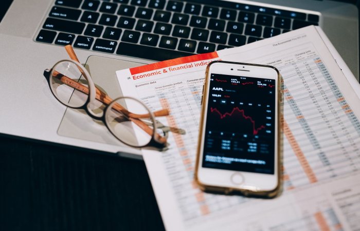 A detailed look at financial tools including a smartphone and laptop for stock analysis.