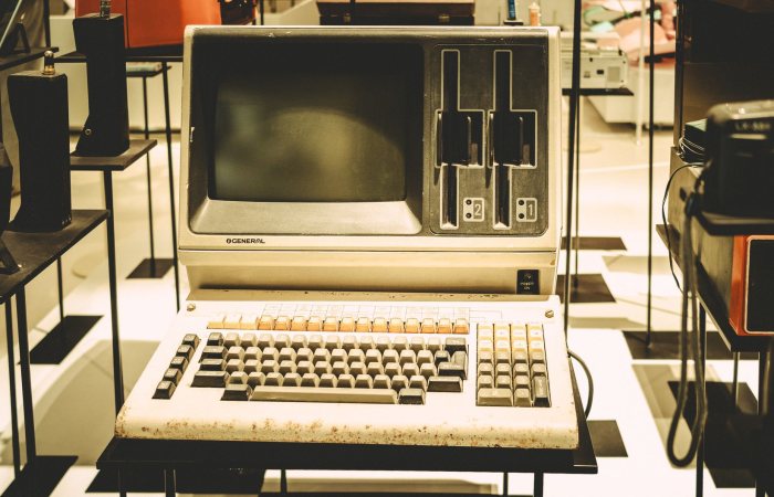 Old-fashioned General computer on display with a vintage keyboard and disk slots.