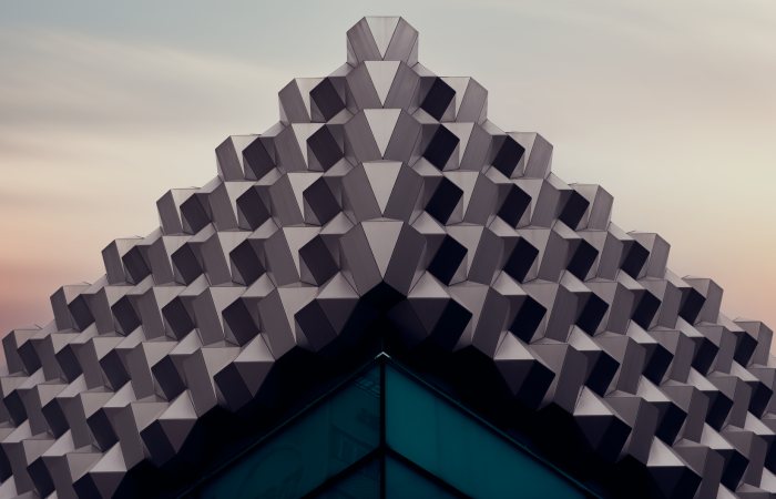 Captivating geometric architecture with a futuristic design against a sunset sky.