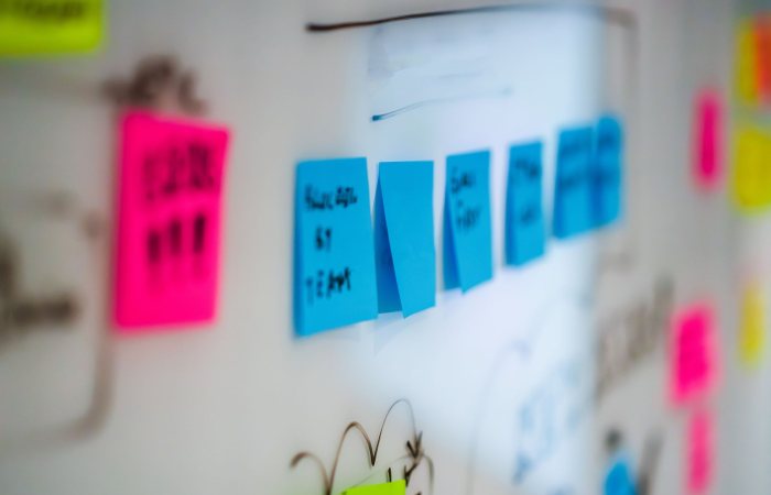 Sticky notes on a whiteboard during a creative brainstorming session in an office.